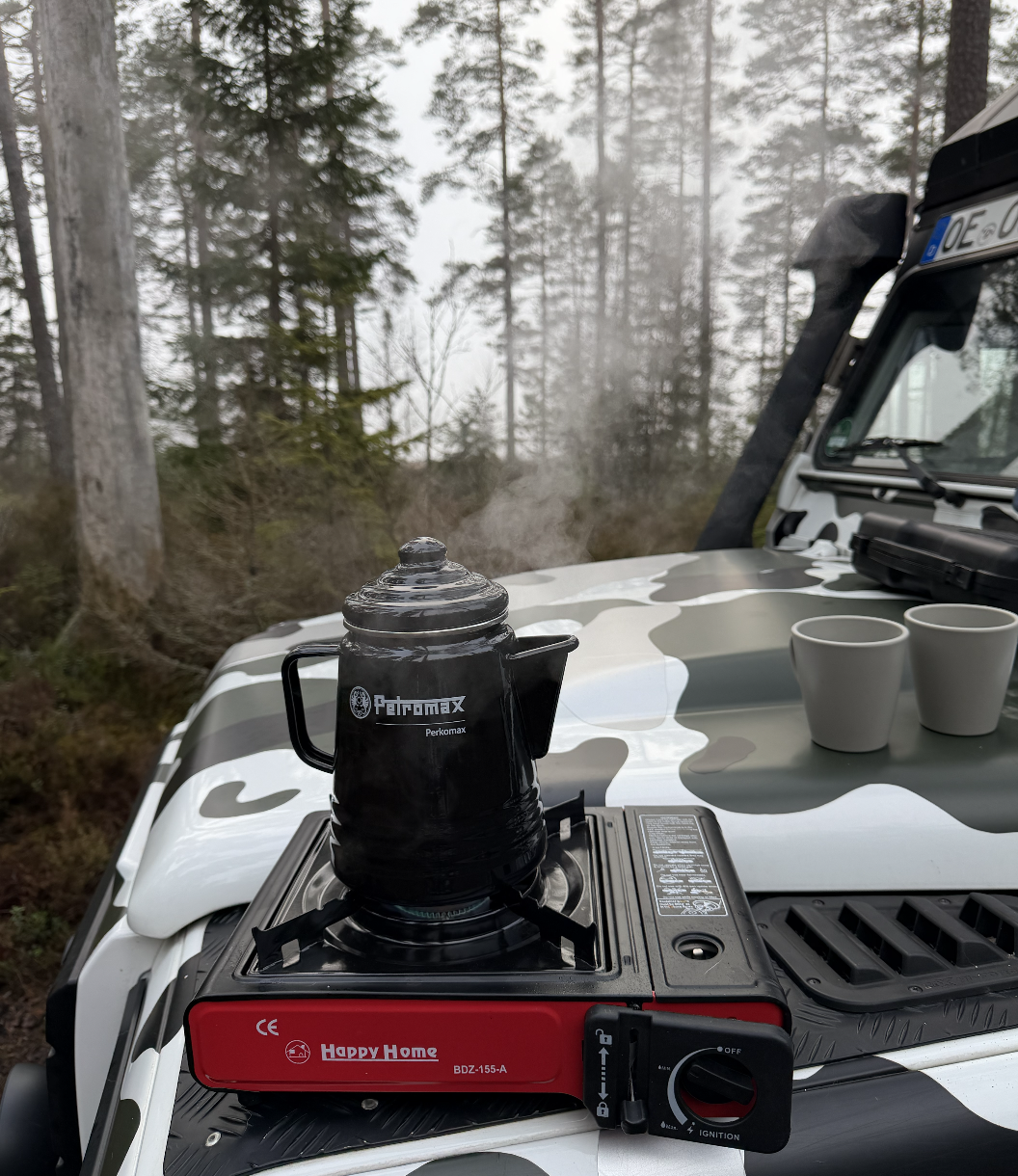 Kaffee auf dem Defender bei einer morgendlichen Pause im Wald